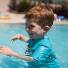 A toddler swims in a pool.