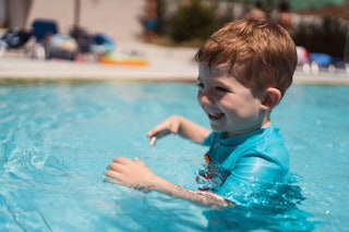 A toddler swims in a pool.