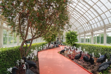sculptures in a greenhouse along a red pathway