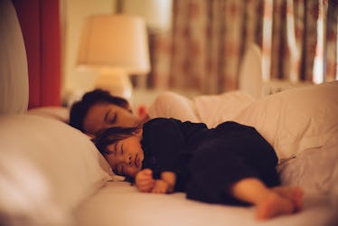 A parent and toddler co-sleeping in a bed.