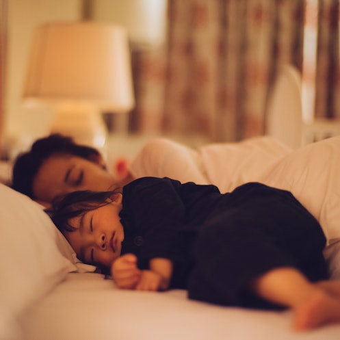 A parent and toddler co-sleeping in a bed.