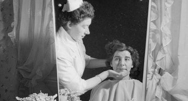 July 1958: Nurse Phyllis Parsonage prepares a patient for some beauty treatment at Saint Matthew's H...