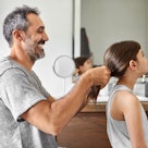A dad doing his daughter's hair.