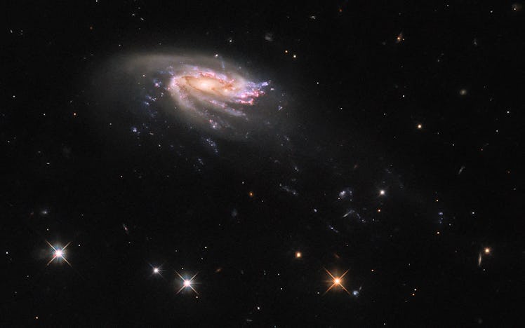 A galaxy appears almost side on, and looks almost like a flying saucer. Its got a glittering disk, a...