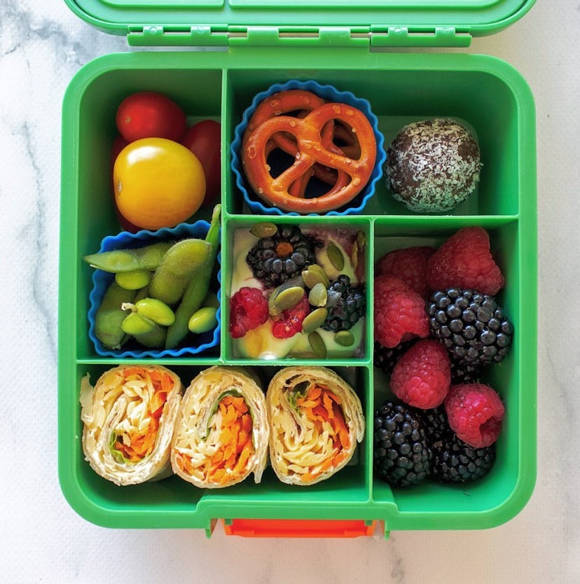 A bento box lunch with wraps and fresh fruit in a story about school lunch ideas.