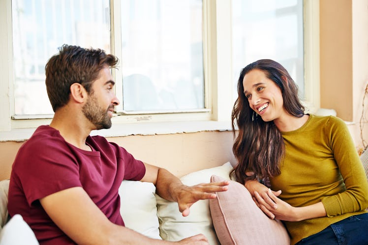 Husband and wife talking on their sofa happy