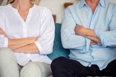 Man and woman sitting on couch with arms crossed