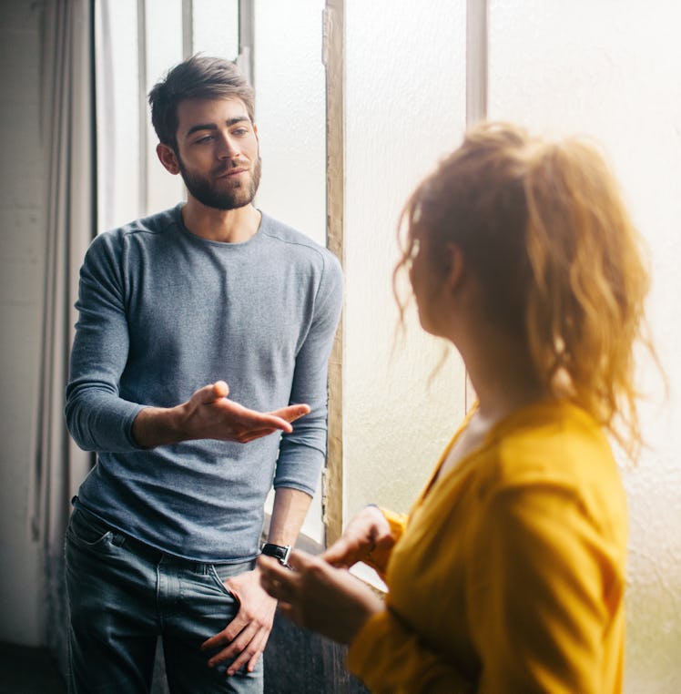 A man looks at and talks to a woman.