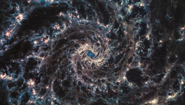 A chaotic swirl shows spokes of dust and gas channeled throughout a galaxy. The streams are twisted ...