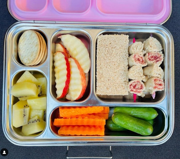 A classic among school lunch ideas: a sandwich, apples, crackers, and veggies.