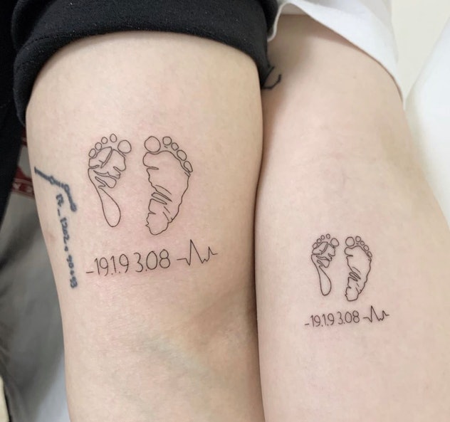 outline of baby footprint tattoo with birthdate and a heart rate symbol underneath