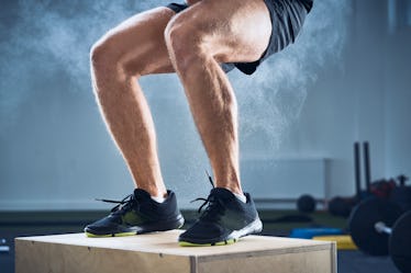 Close up on a man's big calves as he does box jumps.