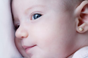 Headshot of a baby with an ear piercing.