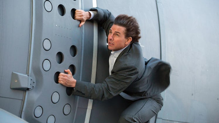 Ethan Hunt (Tom Cruise) holds onto a cargo plane door in 'Mission: Impossible - Rogue Nation'
