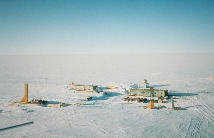 a few small buildings huddle on the ice above Lake Vostok, a lake beneath Antarctica's ice.
