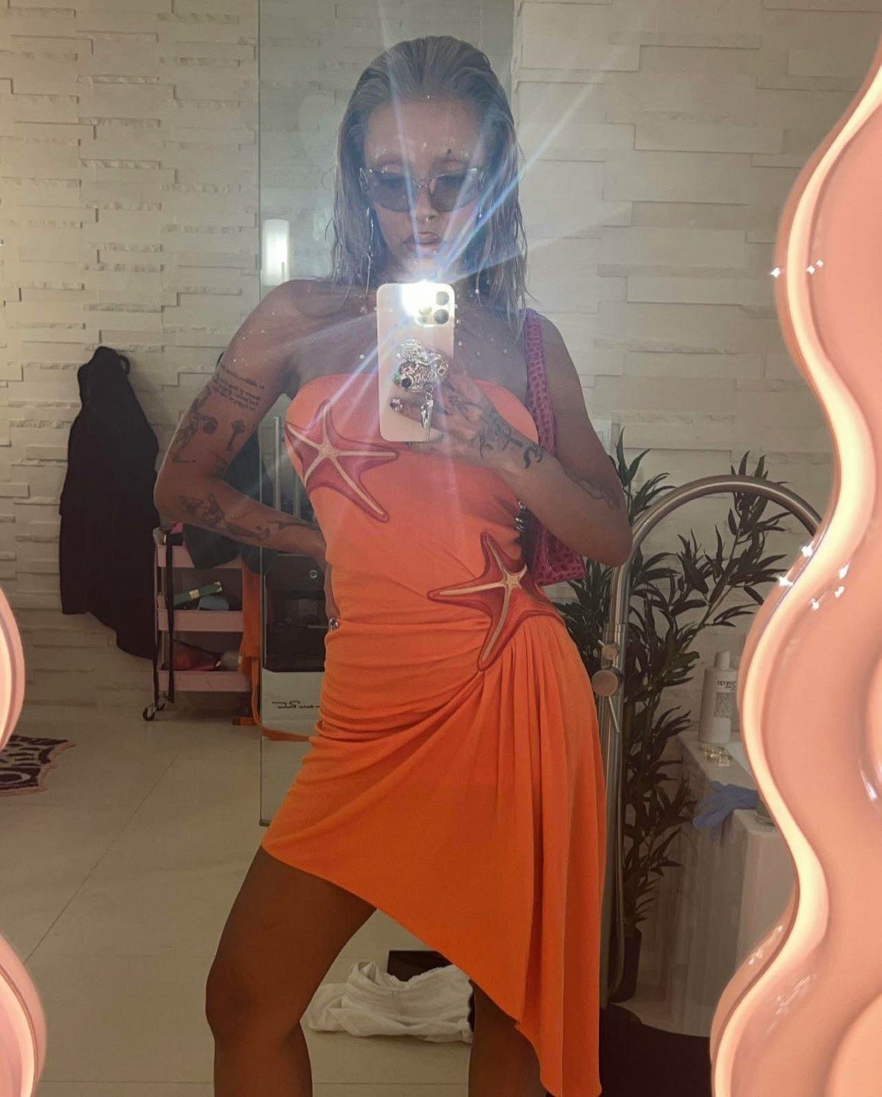 Doja Cat showed off a 3D nail design that included rhinestones, cross nail art, and heart-shaped pea...