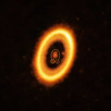 photo showing a bright orange and yellow ring around a fainter orange spot, with several smaller ora...