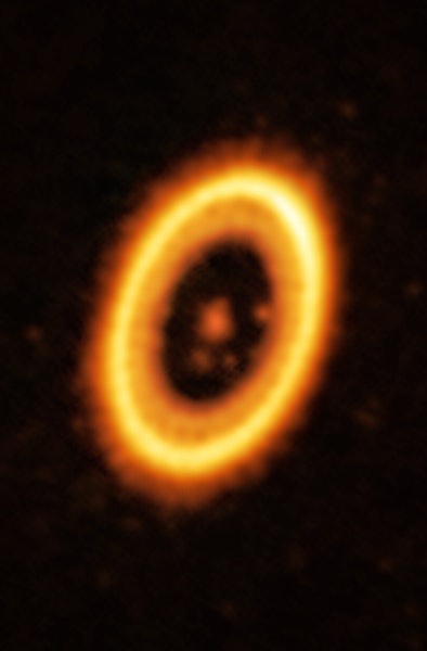photo showing a bright orange and yellow ring around a fainter orange spot, with several smaller ora...