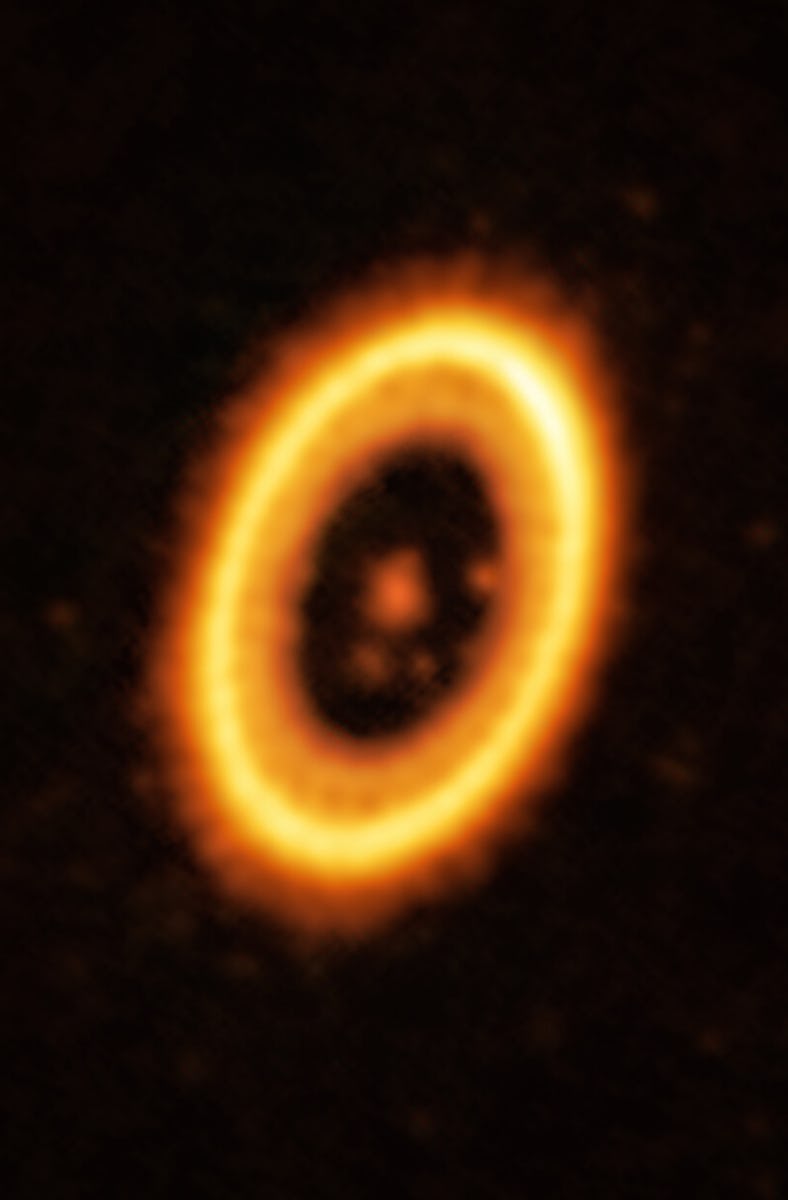 photo showing a bright orange and yellow ring around a fainter orange spot, with several smaller ora...
