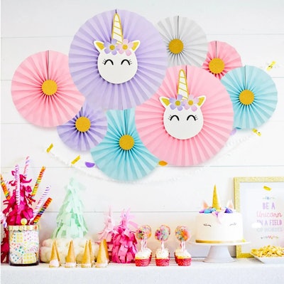 Unicorn paper fans, the perfect backdrop among your other unicorn birthday party decorations.