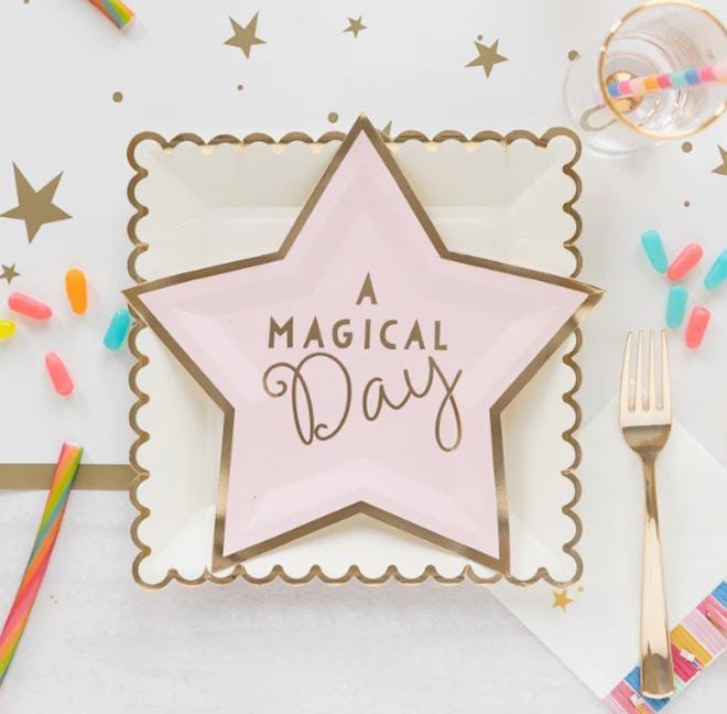 Unicorn birthday party plates in a star shape that read "a magical day"