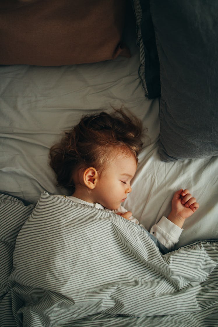 A toddler sleeping in bed.