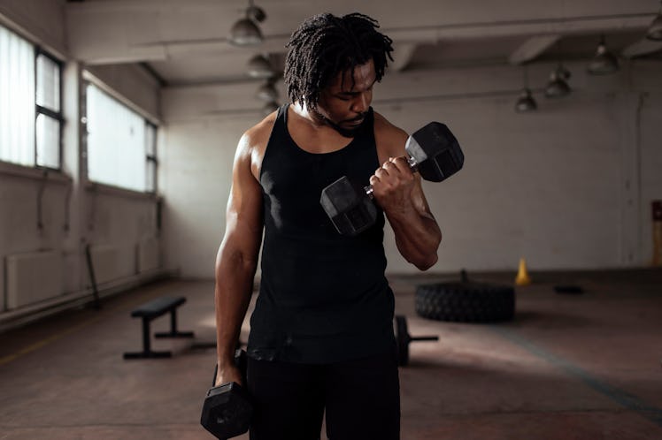 A man doing dumbbell curls during a pull day workout.