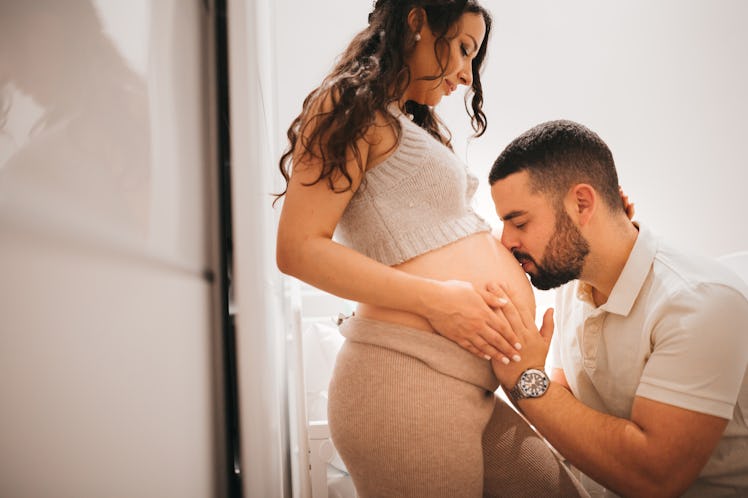Man kissing his pregnant wife's belly