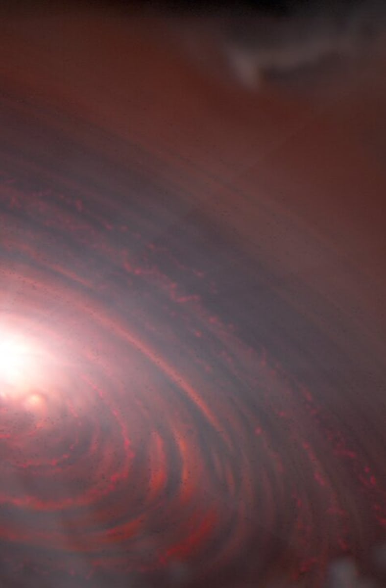 Left of center, a bright light source illuminates a surrounding disc colored dusky red. The disc is ...