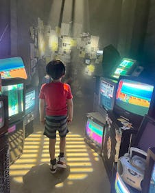 A child surrounded by old video game screens in 2023
