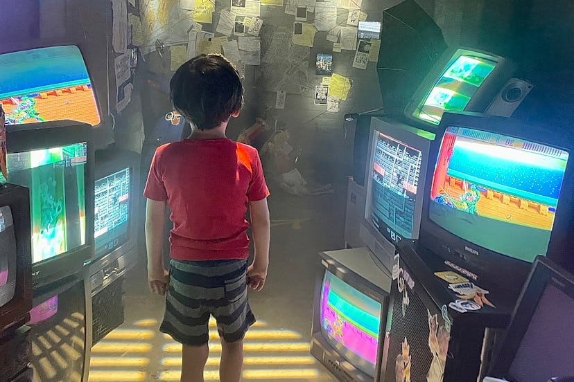 A child surrounded by old video game screens in 2023
