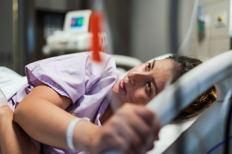 A pregnant woman in a hospital bed masturbating to induce labor.