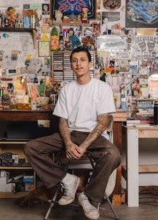 Mario Ayala sitting in his studio in Los Angeles