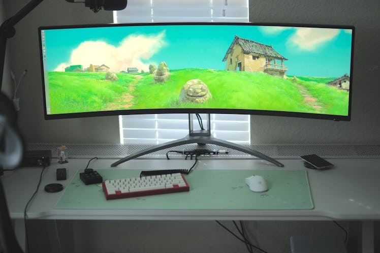 AOC AGON Curved Gaming Monitor with a Studio Ghibli wallpaper.