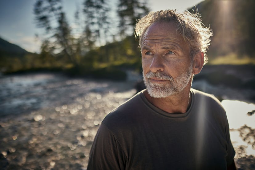 older man standing outdoors deep in thought