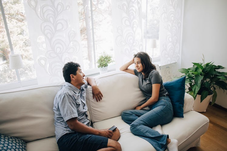 Couple sitting on couch having intense conversation