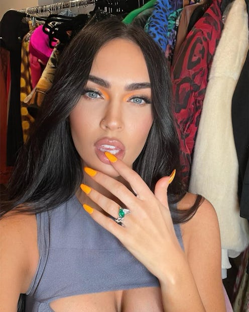 Megan Fox posing with orange nails