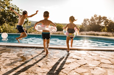 Three children running to jump into a pool.