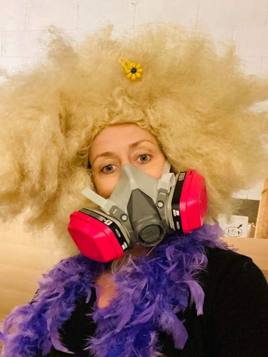The Author poses in the blond wig, boa, and bright pink gas mask she discovered in her storage unit....