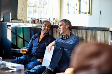 Two middle aged men having a beer and talking in a bar