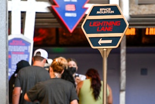 A sign marks the Lightning Lane entrance for Space Mountain at Disney World.