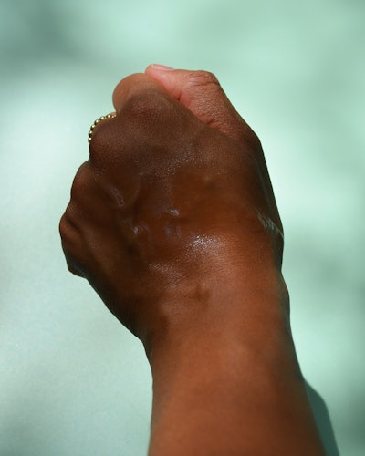 A look at a hand wearing the Sun Bum Original SPF 50 Continuous Spray.