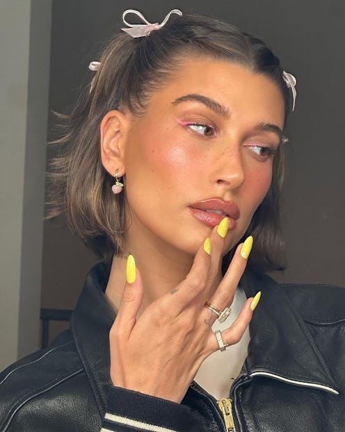 Hailey Bieber pink ribbons and yellow nails