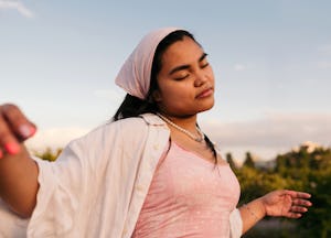 A woman wondering if she can manifest happiness and wellbeing through manifestation methods.