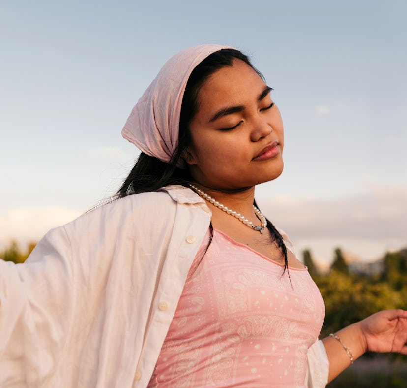 A woman wondering if she can manifest happiness and wellbeing through manifestation methods.