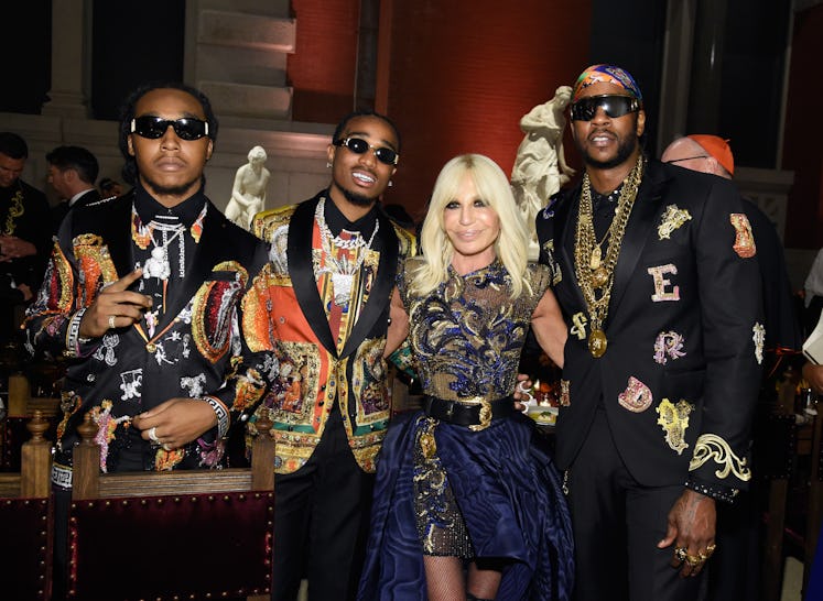 Designer Donatella Versace poses with Migos and 2 Chainz during the Heavenly Bodies: Fashion & The C...