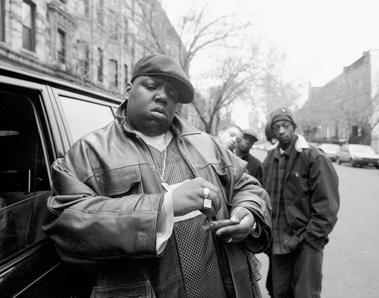 American rapper Notorious B.I.G., aka Biggie Smalls, aka Chris Wallace (1972 - 1997), rolls a cigar ...