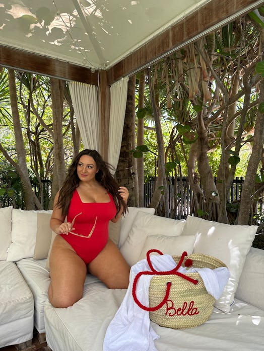 Bella Gerard wears a red TA3 swimsuit with a square neckline.
