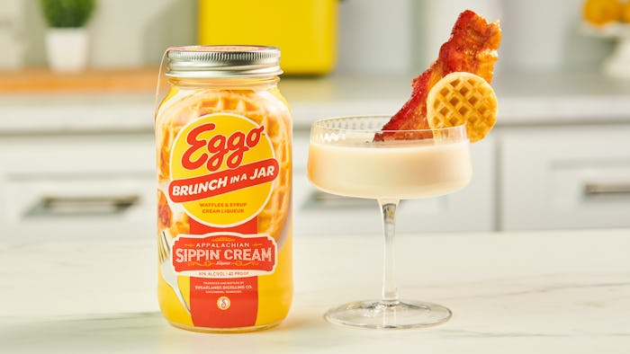 Eggo Brunch in a Jar Sippin' Cream cocktail in a fancy glass with a waffle and bacon as garnish