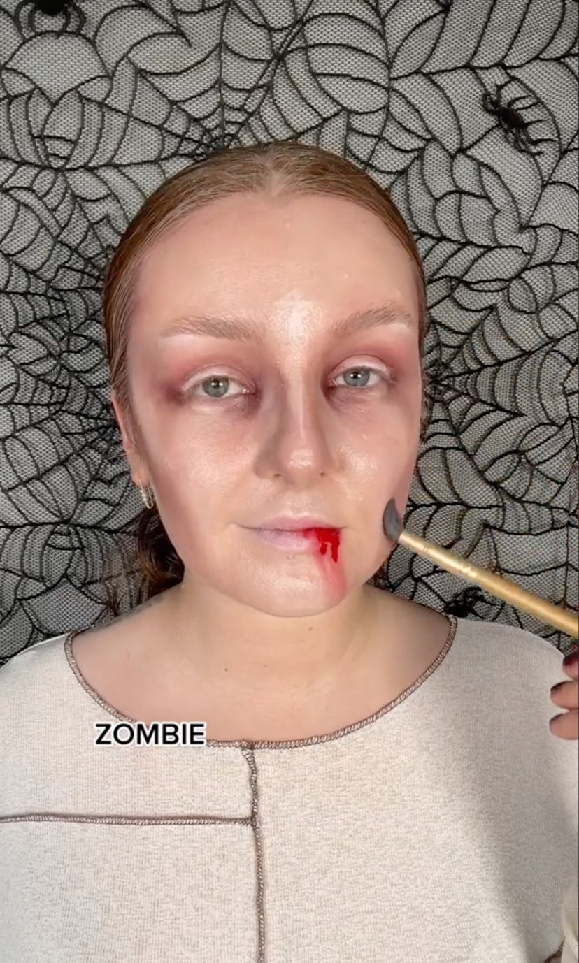 zombie makeup with bruises and blood on the side of the lip